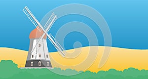 Windmill with yellow field and blue sky.