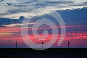 Windmills against a rainbow evening sky