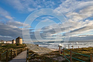 Windmills along the coastal path, Praia da Apulia beach, Portugal