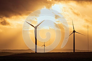 Windmills in a field at sunset on the background of dramatic sky