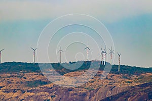 Windmills on the green tree mountain with blue sky