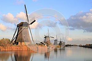 Windmills at Kinderdijk with blue sky and cloud in the background.