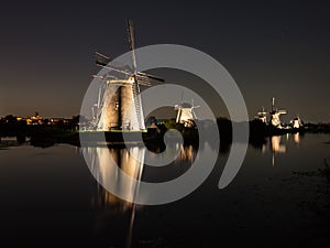 Windmills lit at night