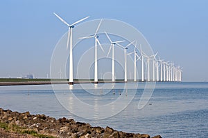 Windmills mirroring in the calm sea