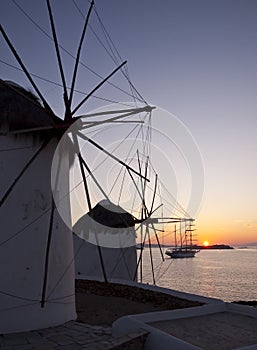 Windmills at Mykonos at sunset at sea and the ship