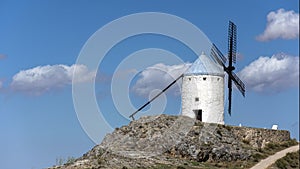 Windmills and old castle in Consuegra, Toledo, Castilla La Mancha, Spain. Blade windmill on a high with cloudy sky background photo