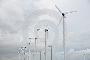 Windmills for renewable electric energy production in windmill farm.