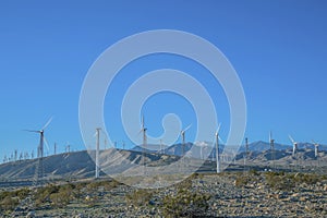 Windmills renewable energy generator againts blue sky background