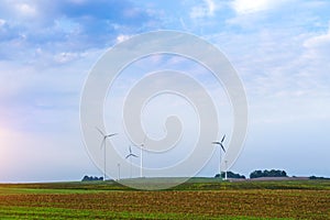 Windmills rotate blades over farmland