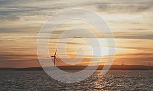 Windmills in the sea at sunset