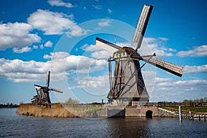 windmills are seen in the water and under the cloudy sky