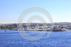 Windmills and st nicholas tower and lighthouse in Mandraki port in Rhodes, Greece