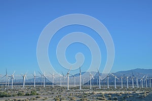 Windmills on a sunny day landscape with mountains and blue sky background