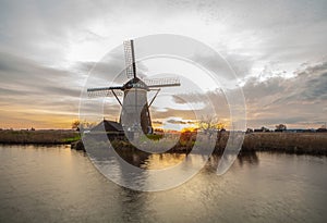 Windmills and water canal on sunset in Kinderdijk, Holland