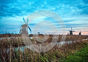 Windmills and water canal on sunset in Kinderdijk, Holland