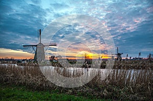 Windmills and water canal on sunset in Kinderdijk, Holland