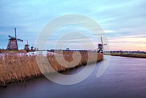 Windmills and water canal on sunset in Kinderdijk, Holland