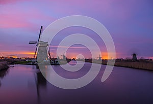 Windmills and water canal on sunset in Kinderdijk, Holland