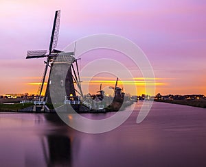 Windmills and water canal on sunset in Kinderdijk, Holland