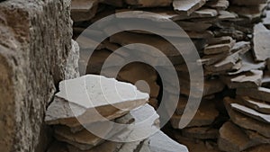 Window in ancient stone wall, pile of stones, remains of settlement of Akrotiri