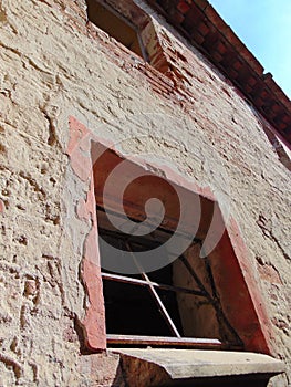 window with bars, abandoned medieval house, Toiano, Pisa, Italy.