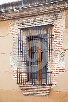 Window with bars on a brick wall.