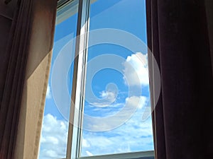 The window from the bedroom overlooks the daytime sky