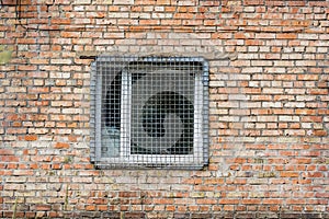 The window behind the iron grate in a brick wall.