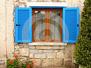 Window with blue shutters of an old building in Alacati, Izmir, Turkey