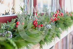 Window box decorated for the holidays with fresh greens and red berries