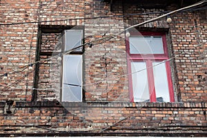 Window on the brick facade of an old house with hanging lights o