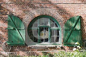 Window in a brick farmhouse with shutters in Schleswig Holstein, Germany photo