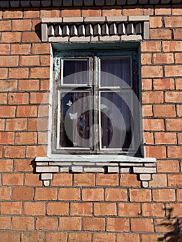 Window in a brick house. Dilapidated window frame.