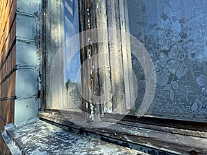Window in a brick house. Dilapidated window frame.