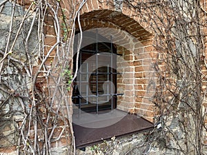 Window in the brick wall of the castle. Window opening in a medieval building. Wall with a window in the old fortress