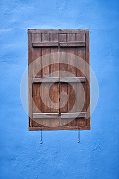 The window with the brown shutter in the blue wall. Cyprus