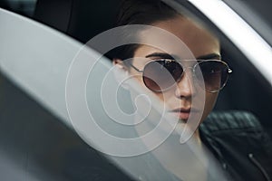 Window, car and face of woman with sunglasses for cool style and accessory while driving on a trip. Edgy, trendy and