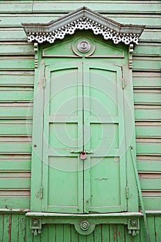 Window with carving architraves and closed shutters