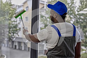 Window cleaner with scraper with sponge for cleaning glass in blue baseball cap