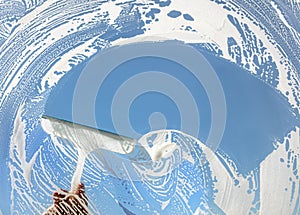 Window cleaner using a squeegee to wash a window