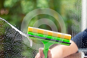 Window cleaner using a squeegee to wash a window