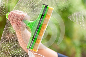 Window cleaner using a squeegee to wash a window