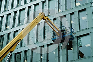 A window cleaner works on the glass facade of an office building