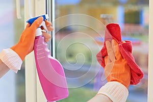 Window cleaning. Hands in gloves with a spray and a rag photo