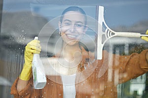 Window cleaning portrait, smile and happy woman at home washing windows with glass cleaner. Helping, working and maid