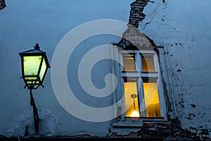 Okno s prasknutím a pouliční lampou večer v jedné z malých uliček Bratislavy
