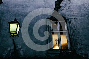 Window with a crack and street lamp in the evening in one of the small streets of Bratislava