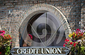 Window of a credit union surrounded by flower baskets