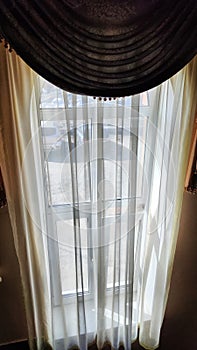 Window with dark dense and tulle transparent curtains. Abstract background, location, texture, frame and copy space