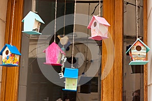 Window, decorated with a branch with some hanging small birdhouses, on \